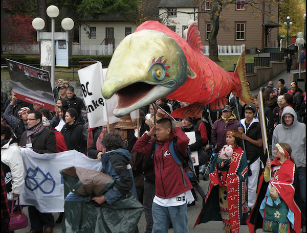 Group of people at a protest with a large fish puppet